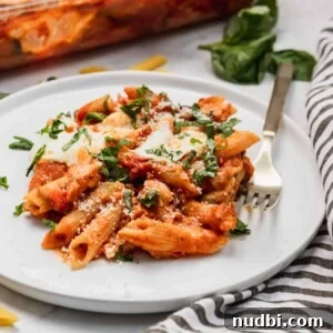 Cheesy Chicken Parmesan Casserole Bake for Weeknight Dinners 7 Chicken parmesan casserole on plate with fresh parsley.