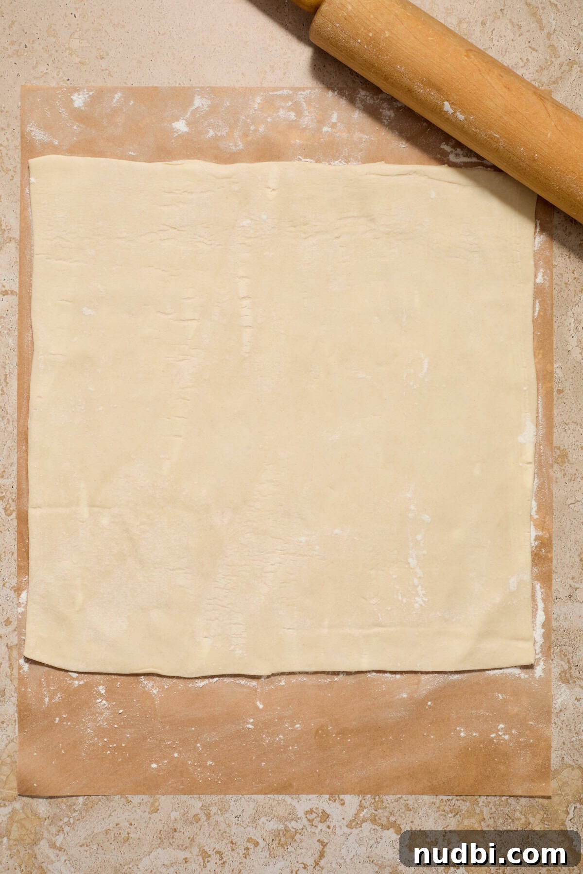 Quick Puff Pastry Cinnamon Rolls with Sticky Cinnamon Glaze 4 Rolled puff pastry on lightly flour dusted parchment paper.