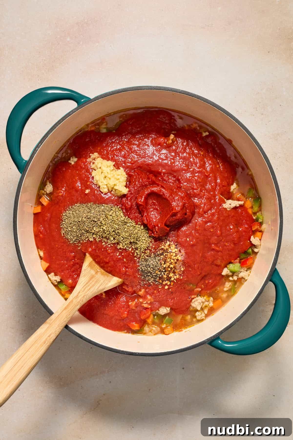 Savory Ground Turkey Spaghetti Sauce Recipe 8 Crushed tomatoes, seasoning, garlic and other ingredients added to pot with meat and vegetables.