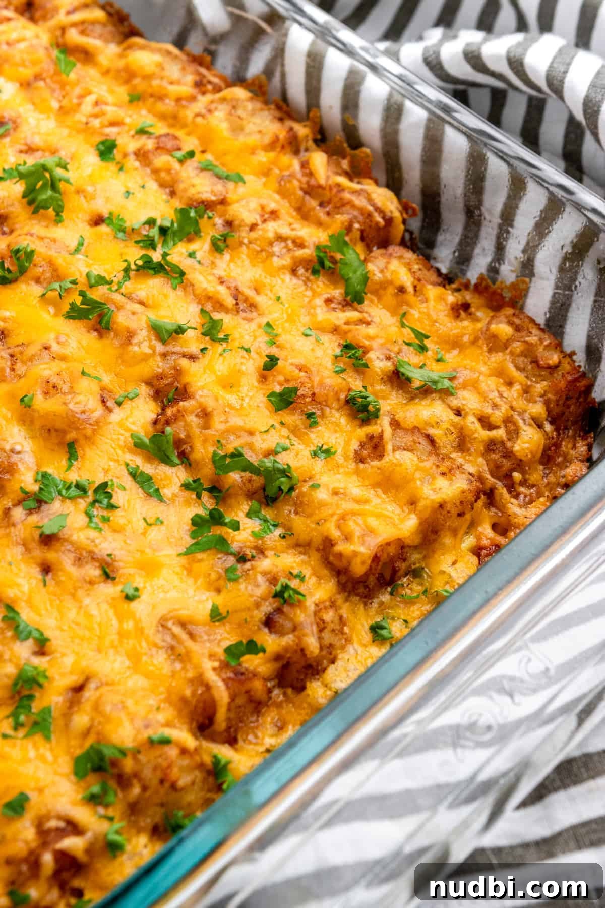 Cheesy Tater Tot Breakfast Casserole with Sausage and Eggs 6 Breakfast casserole with tator tots and cheese on top.