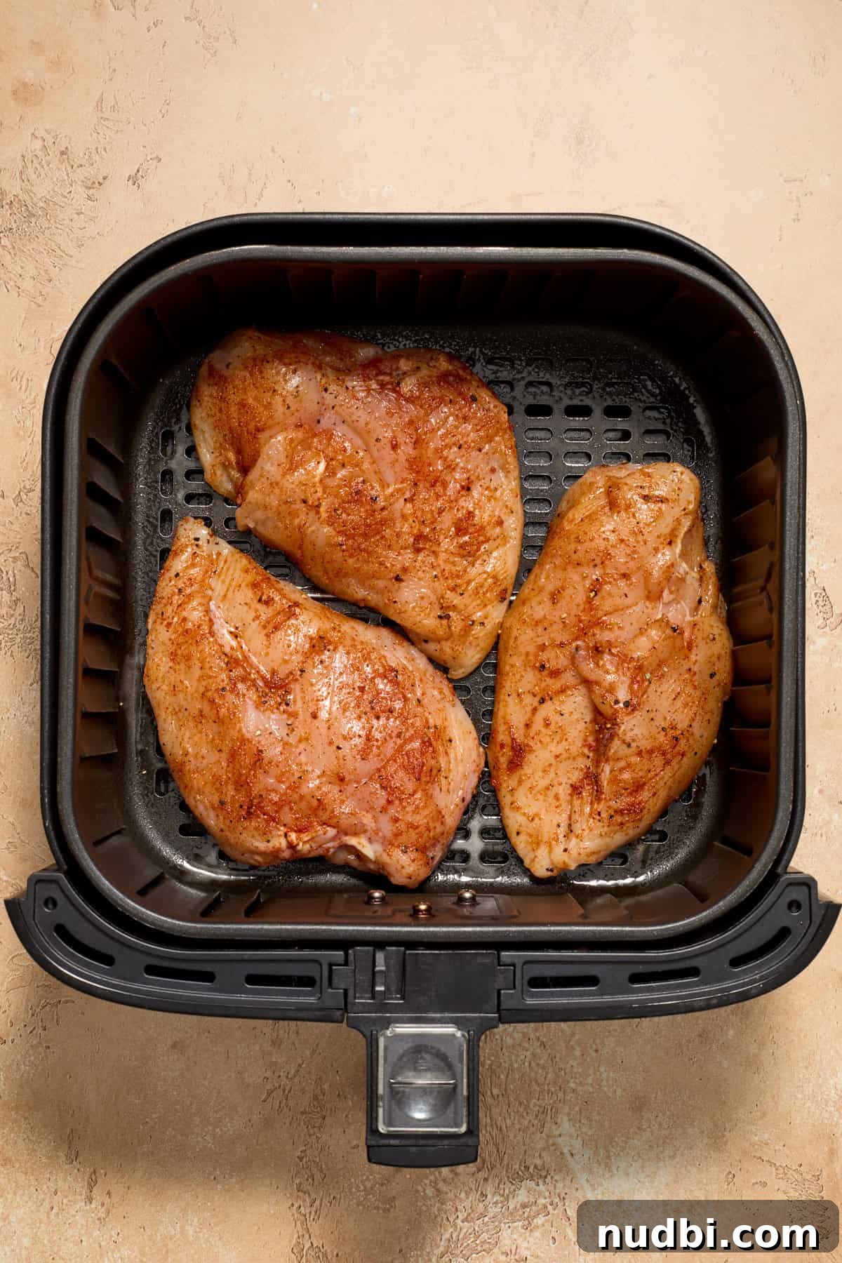 Juicy BBQ Chicken Breast in the Air Fryer — Quick Recipe 6 Chicken in air fryer before being cooked.