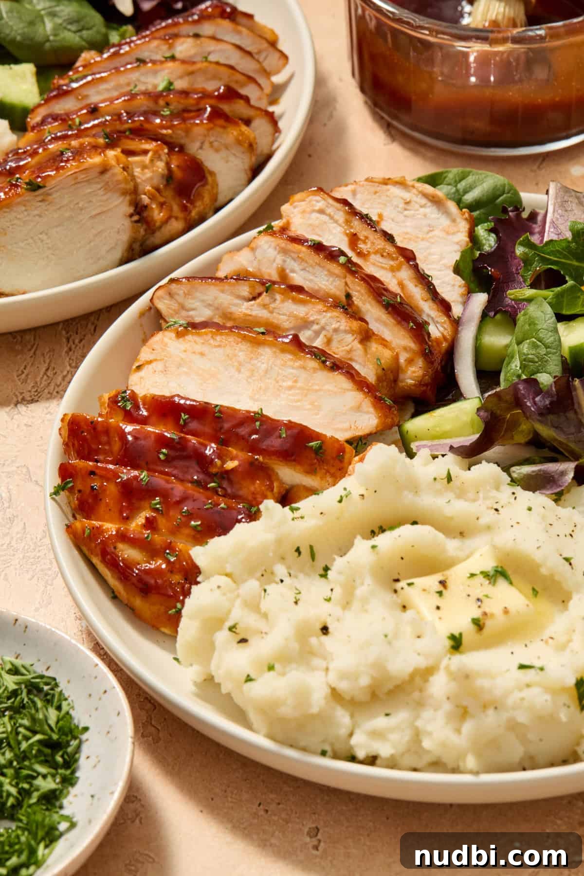 Juicy BBQ Chicken Breast in the Air Fryer — Quick Recipe 9 Sliced chicken on plate with mashed potatoes and salad.