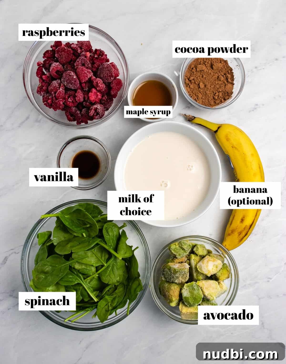 Creamy Chocolate Raspberry Smoothie with Avocado Boost 3 Spinach, cocoa powder, avocado, banana and ingredients labeled on counter.