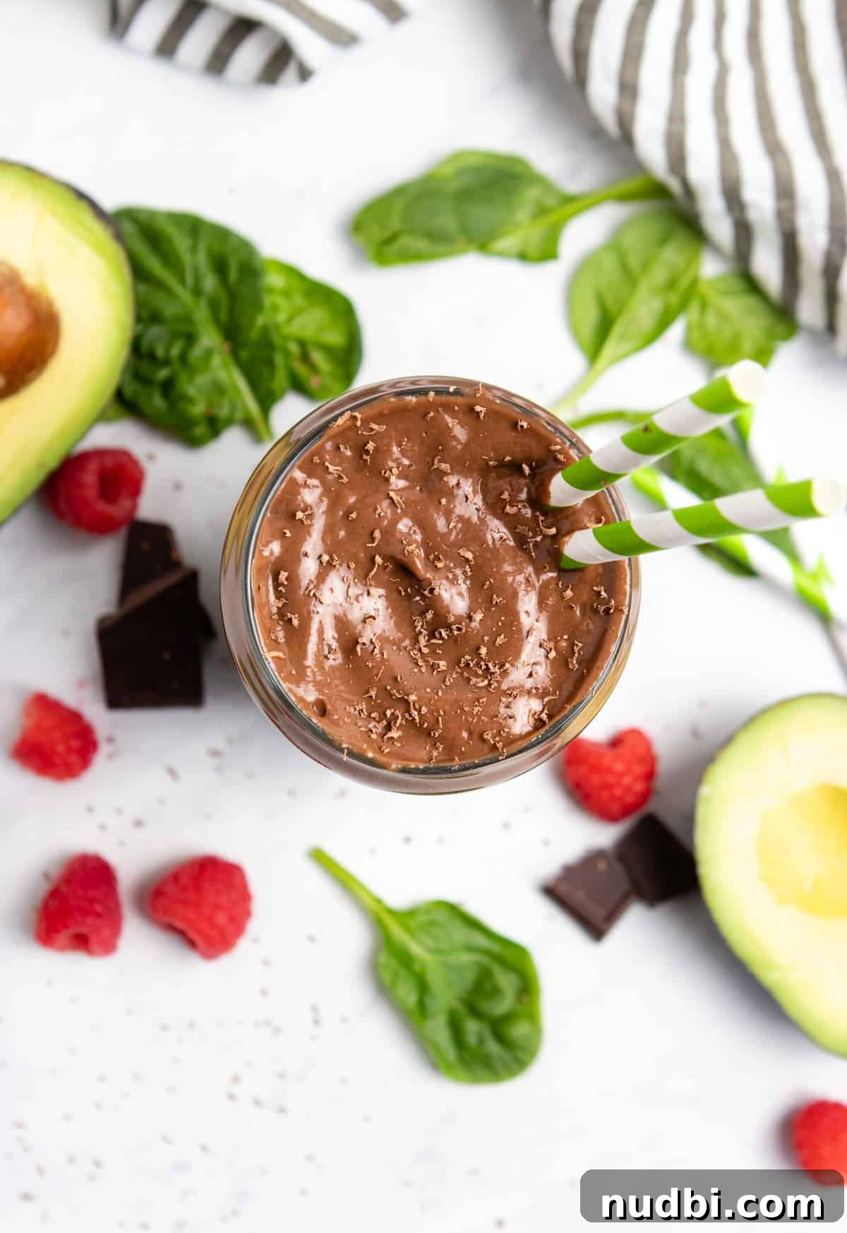 Chocolate Raspberry Avocado Smoothie Recipe for Creamy Antioxidant Boost 5 Overhead view of chocolate smoothie with spinach, avocado and raspberries next to it.