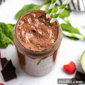 Creamy Chocolate Raspberry Smoothie with Avocado Boost 6 Chocolate raspberry smoothie with avocado and spinach on counter.