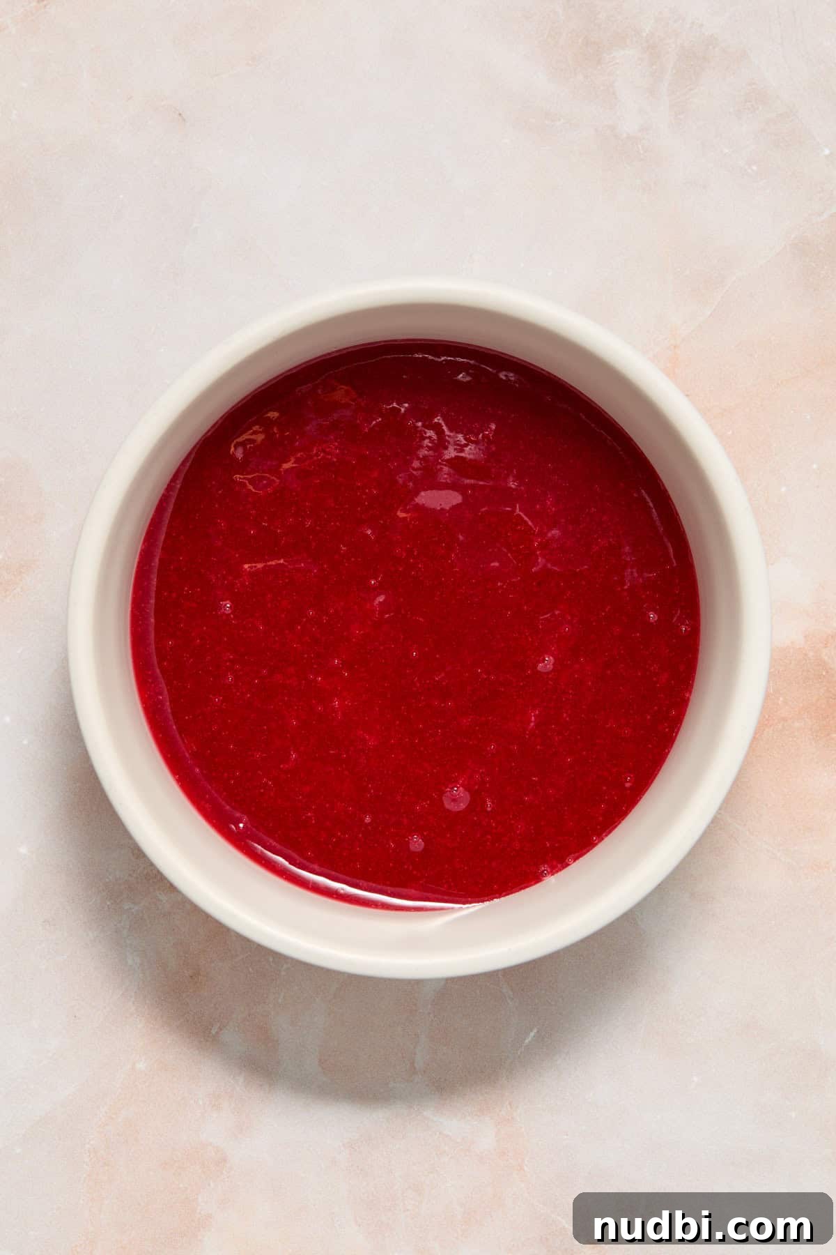 White Chocolate Raspberry Cheesecake Bars Recipe 7 Homemade raspberry sauce in white bowl.