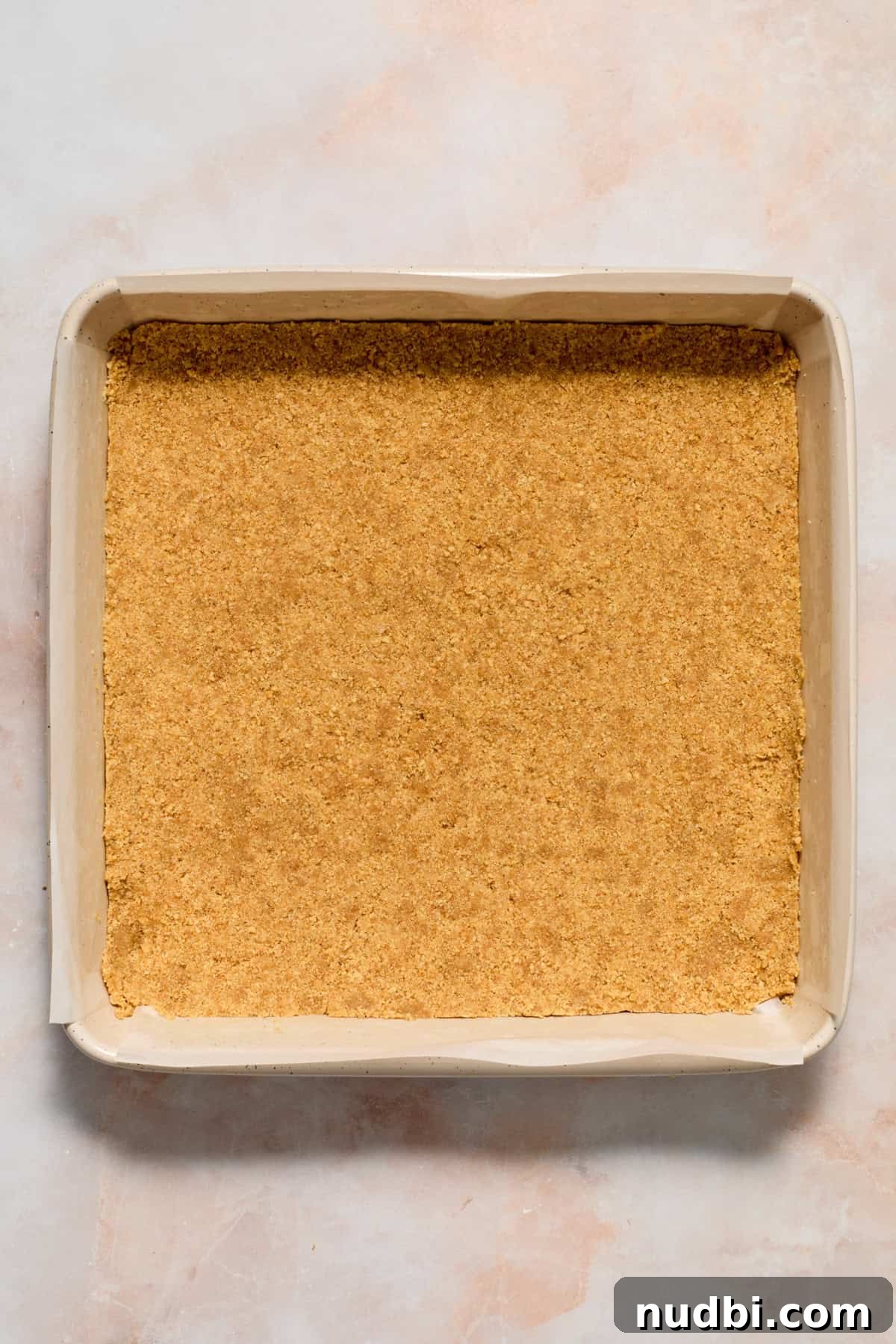 White Chocolate Raspberry Cheesecake Bars Recipe 10 Graham crust pressed into parchment lined square baking pan.