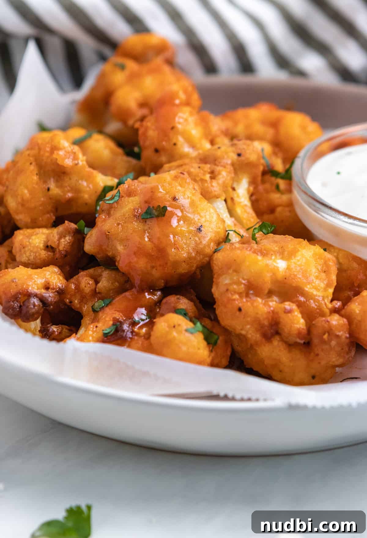 Crispy Air Fryer Buffalo Cauliflower Bites 2 Plate of air fryer buffalo cauliflower with fresh parsley.