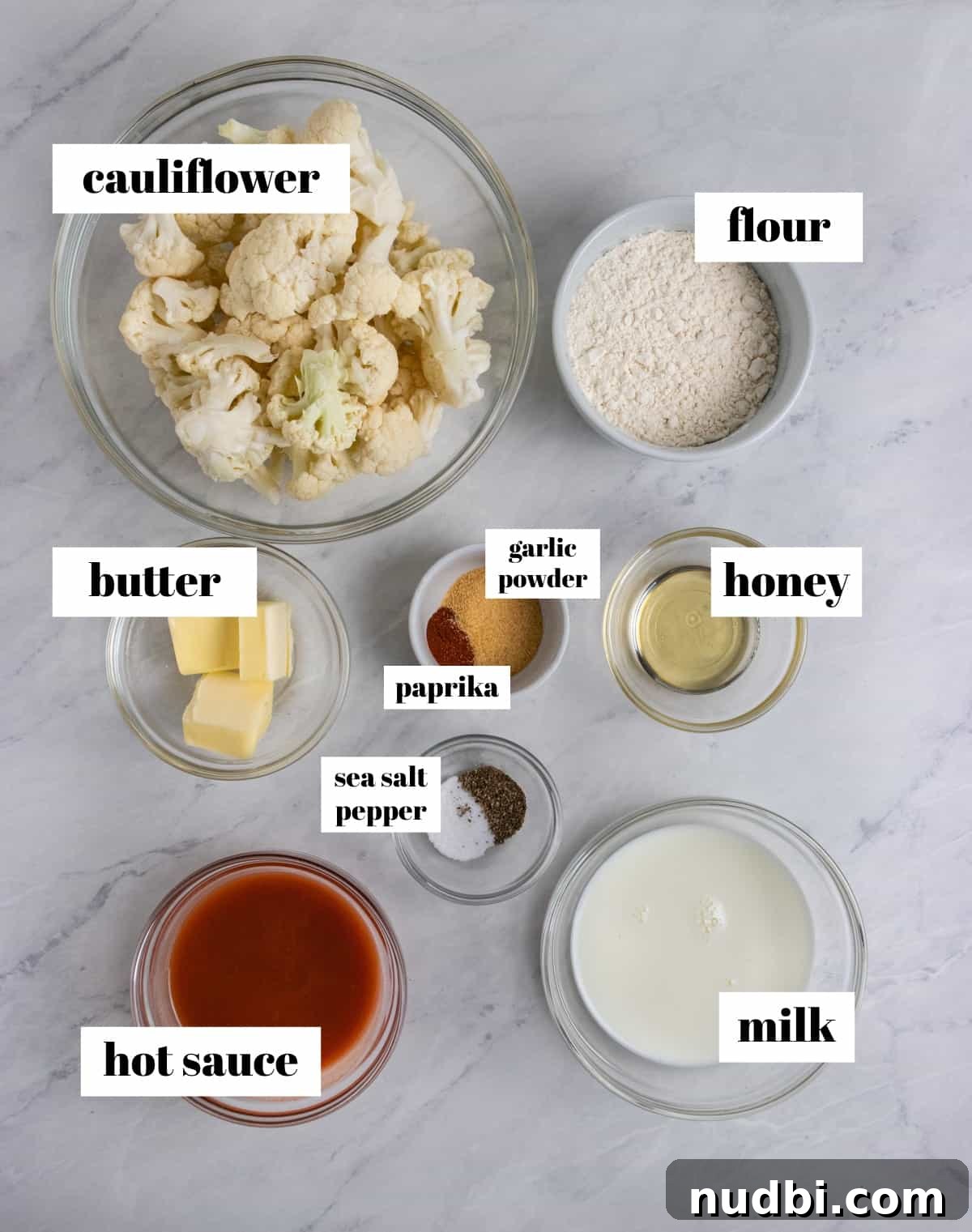 Crispy Air Fryer Buffalo Cauliflower Bites 3 Hot sauce, butter, milk, flour and other ingredients labeled on counter.