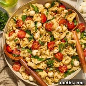 Caprese Tortellini Salad with Cherry Tomatoes and Basil 10 Tortellini caprese salad in bowl topped with balsamic glaze.