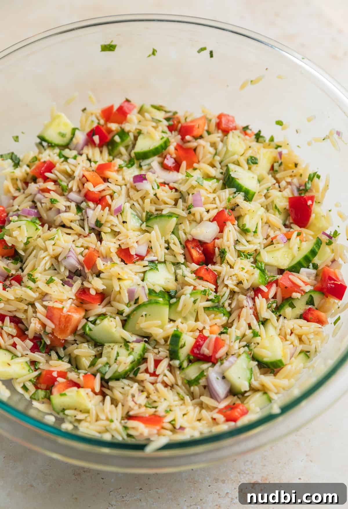 Lemon Orzo Salad with Feta, Herbs & Olive Oil Dressing 6 Orzo salad ingredients tossed together in glass mixing bowl before adding feta.
