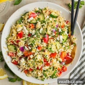 Lemon Orzo Salad with Feta, Herbs & Olive Oil Dressing 10 Lemon orzo salad with cucumber, bell pepper and feta in serving dish with serving utensils.