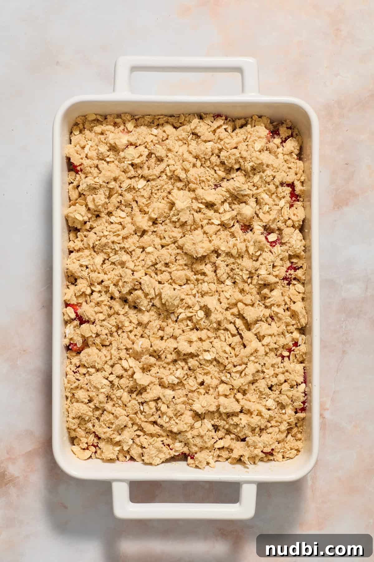Strawberry Crumble Recipe with Buttery Oat Topping 9 Crumble topping on strawberry layer before baking.