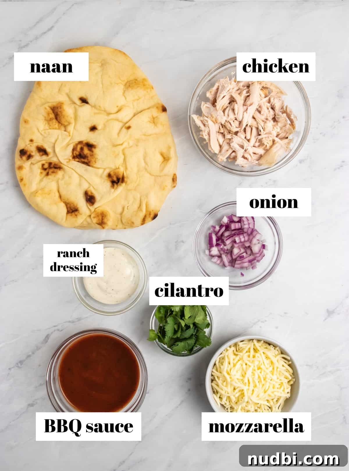 BBQ Ranch Chicken Flatbread Recipe — Crispy, Flavor-Packed Meal 3 Naan, chicken, ranch, cilantro and other ingredients labeled on counter.
