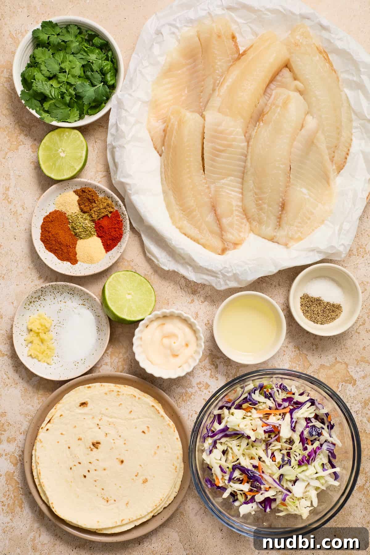 Crispy Air Fryer Fish Tacos with Cilantro-Lime Slaw 4 Fish, tortillas, slaw, spices and other ingredients labeled on a counter.