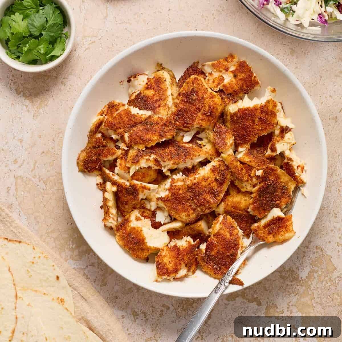 Crispy Air Fryer Fish Tacos with Cilantro-Lime Slaw 9 Flaked fish for tacos in bowl.