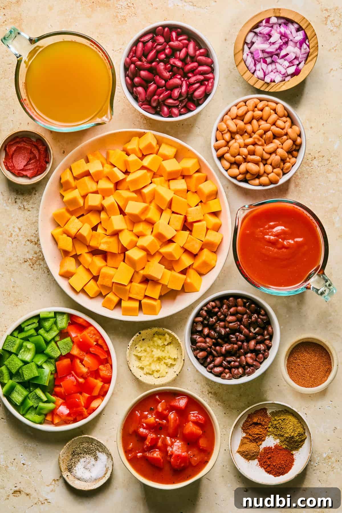 Hearty Butternut Squash Chili Recipe for Cozy Weeknights 3 Beans, broth, cubed butternut squash, peppers and other ingredients on surface.