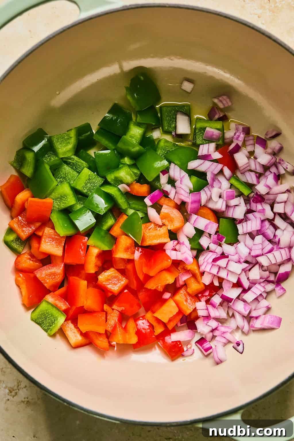 Hearty Butternut Squash Chili Recipe for Cozy Weeknights 4 Red onion and bell peppers in dutch oven pot being sautéed.