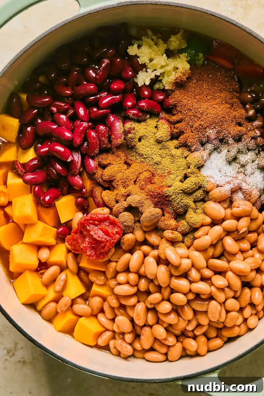 Hearty Butternut Squash Chili Recipe for Cozy Weeknights 6 Beans, squash, seasoning, green chiles and other ingredients added to stock pot.