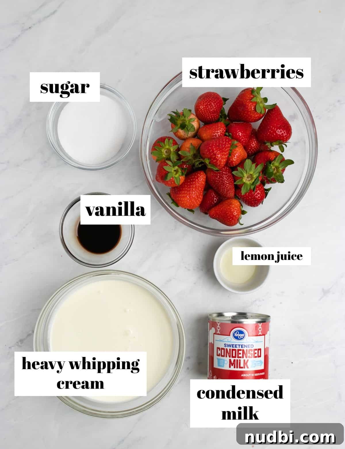 Creamy No-Churn Strawberry Ice Cream Recipe 3 Strawberries, cream, condensed milk and other ingredients labeled on a counter.