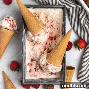 Creamy No-Churn Strawberry Ice Cream Recipe 8 Overhead view of strawberry ice cream in container with cones and fresh strawberries.