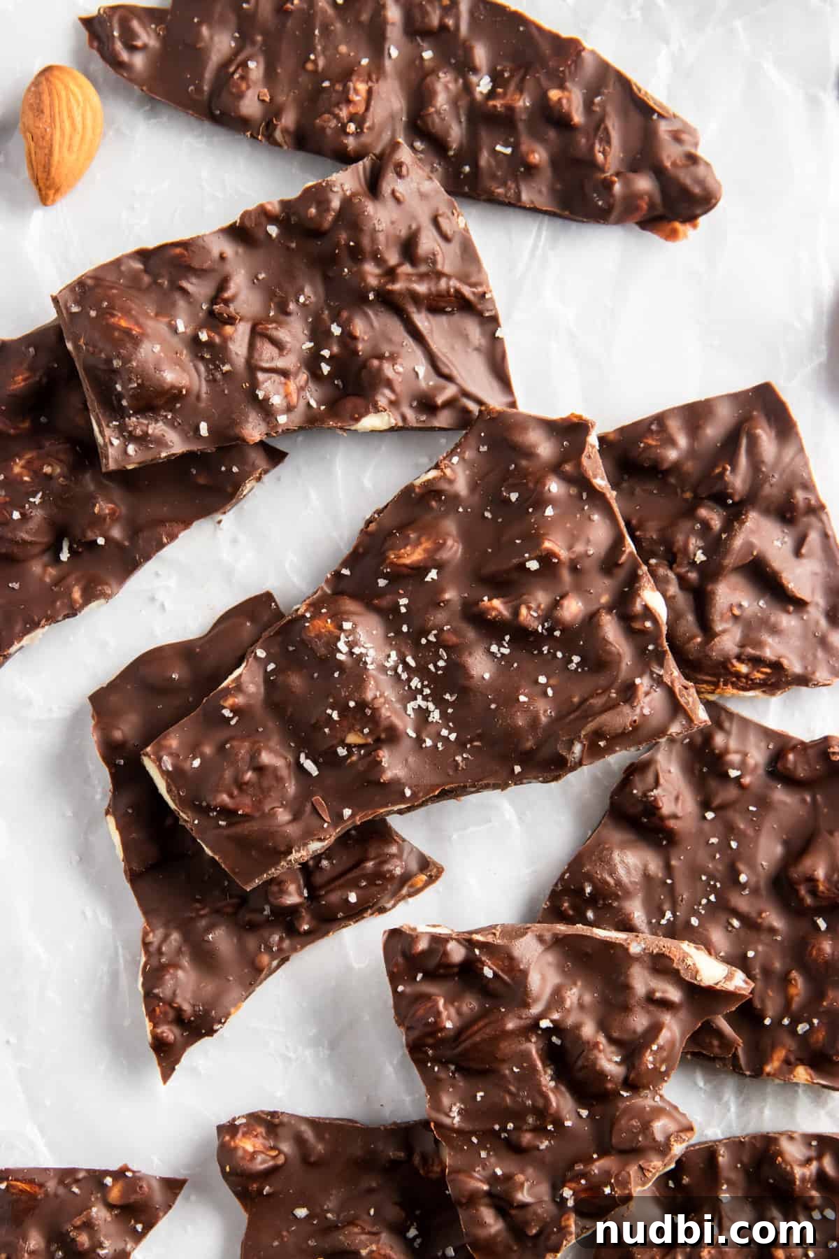 Sea Salt Dark Chocolate Almond Bark Thins Recipe 2 Dark Chocolate Almond Bark pieces on parchment paper.