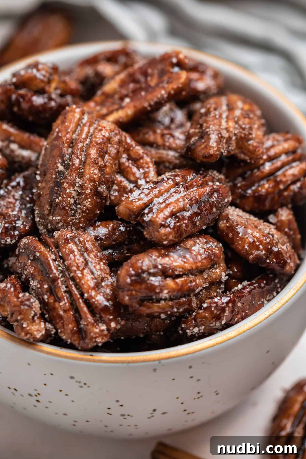 Maple-Glazed Candied Pecans Recipe for Holiday Snacking 2 Ceramic bowl with gold trim with candied maple pecans.