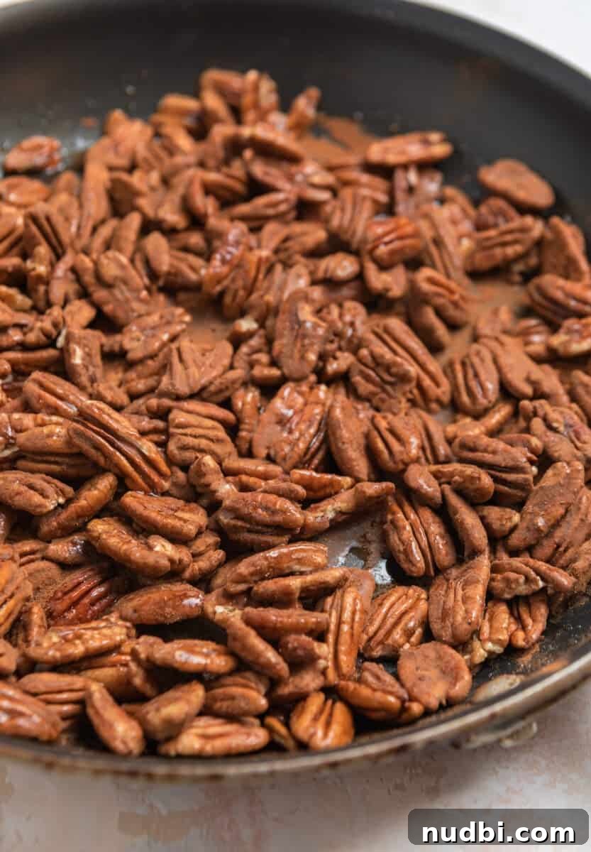 Maple-Glazed Candied Pecans Recipe for Holiday Snacking 5 Cinnamon sprinkled over pecans.