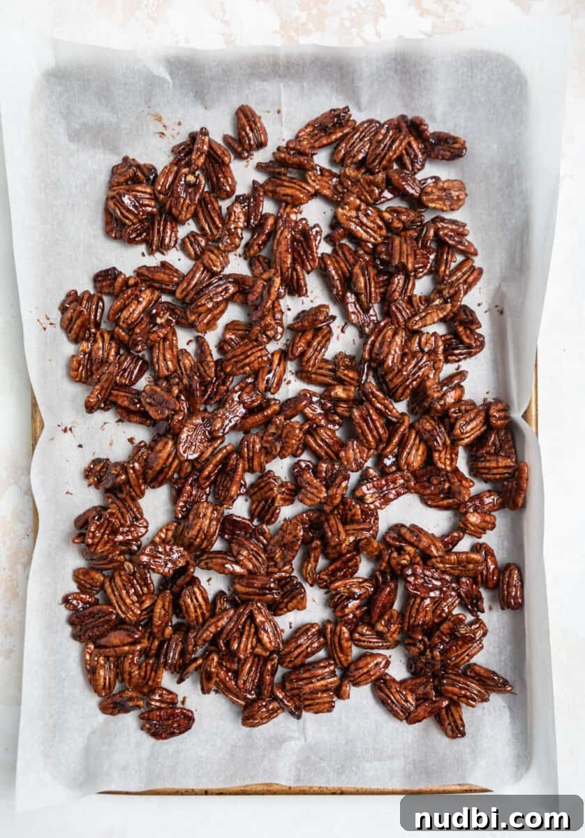 Maple-Glazed Candied Pecans Recipe for Holiday Snacking 7 Lined cookie sheet with cooling maple pecans.