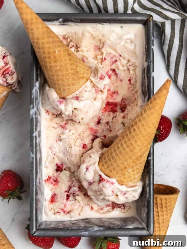 Strawberry and Peach Shortcake Recipe | Summer Dessert Guide 15 Overhead view of strawberry ice cream in container with cones and fresh strawberries.