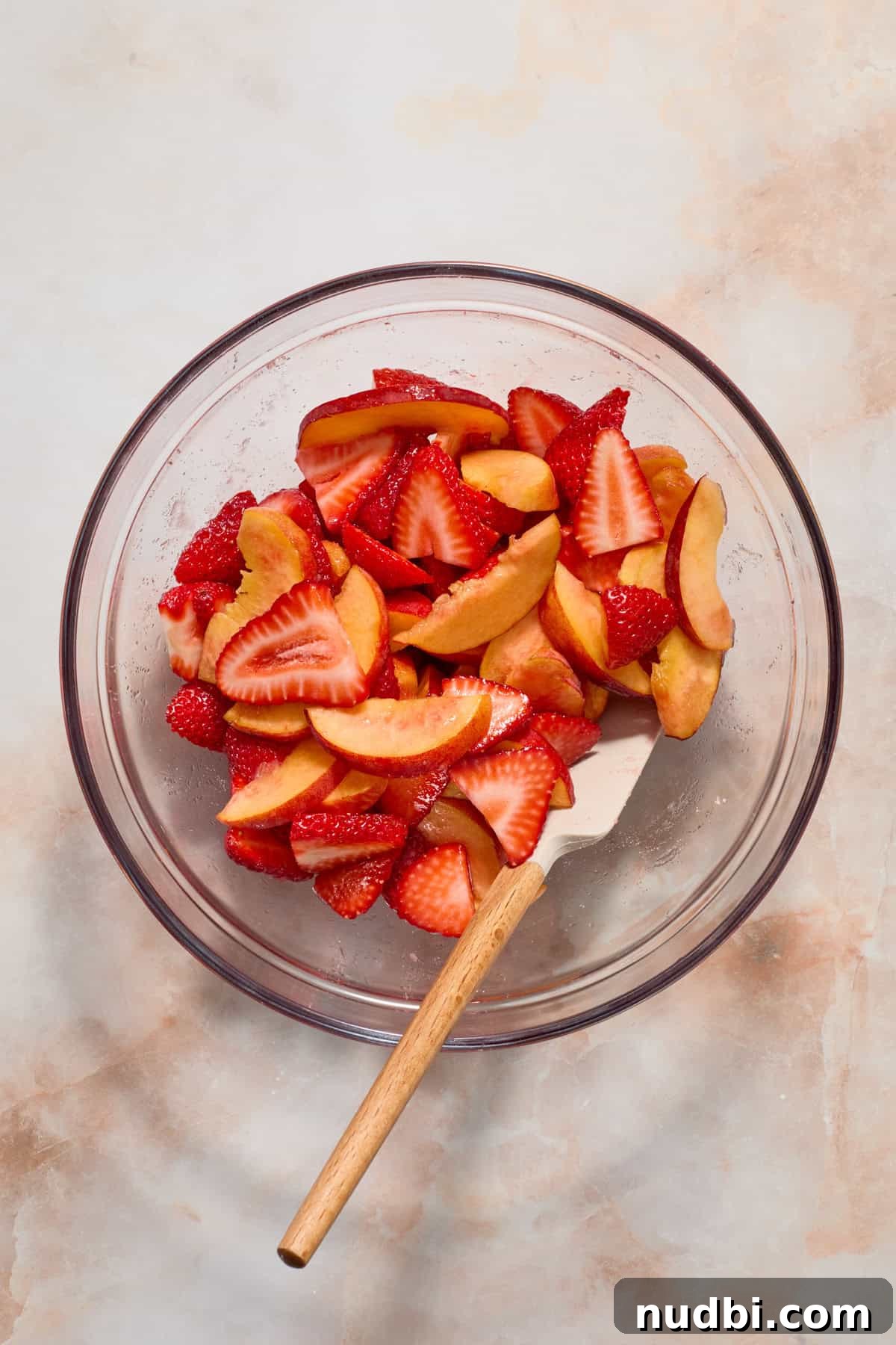 Strawberry and Peach Shortcake Recipe | Summer Dessert Guide 4 Strawberries and peaches in glass bowl with spatula.
