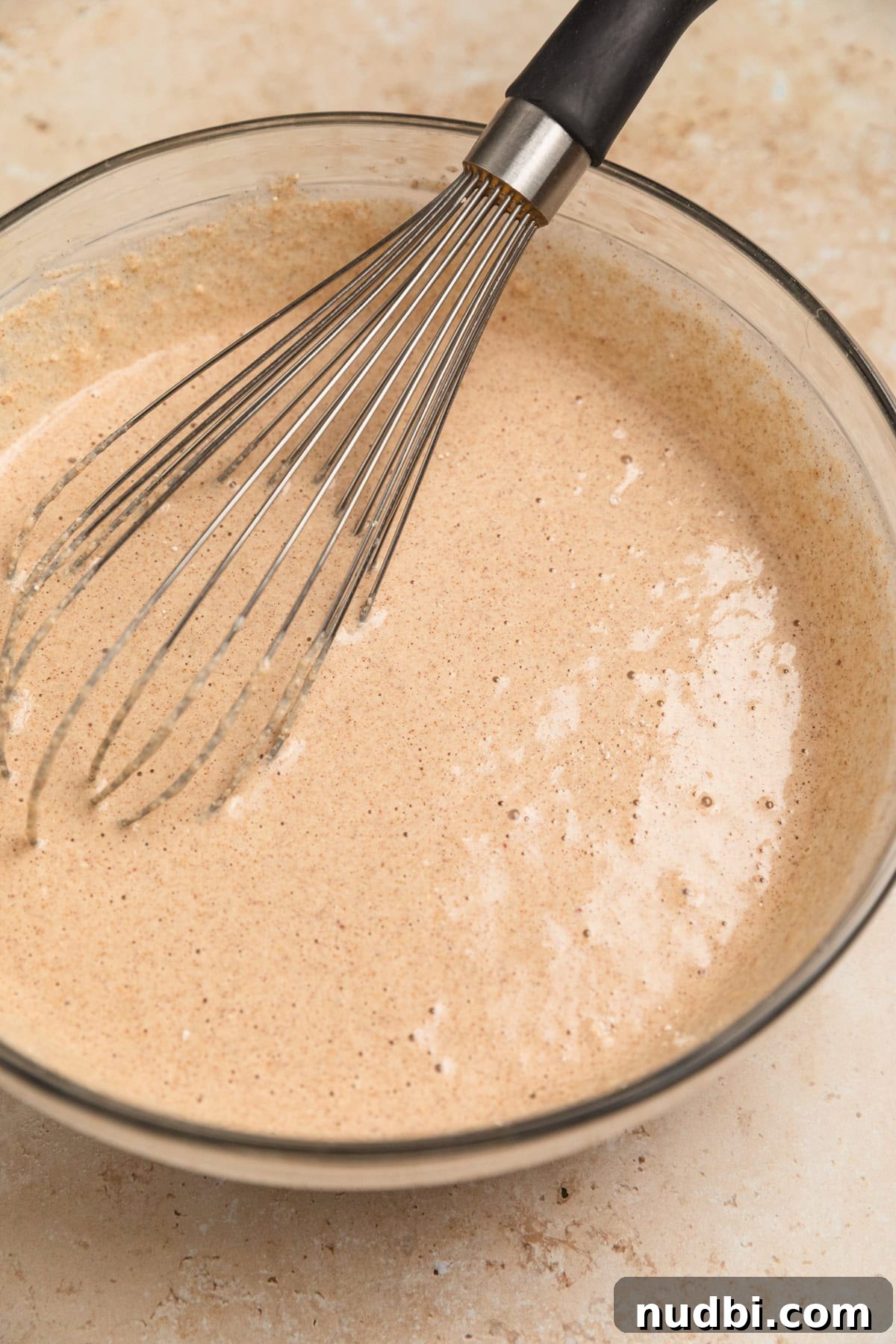 Apple Cinnamon Oatmeal Pancakes Recipe: Fluffy, Whole-Grain Breakfast 10 A bowl of apple oatmeal pancake batter with a whisk in it.