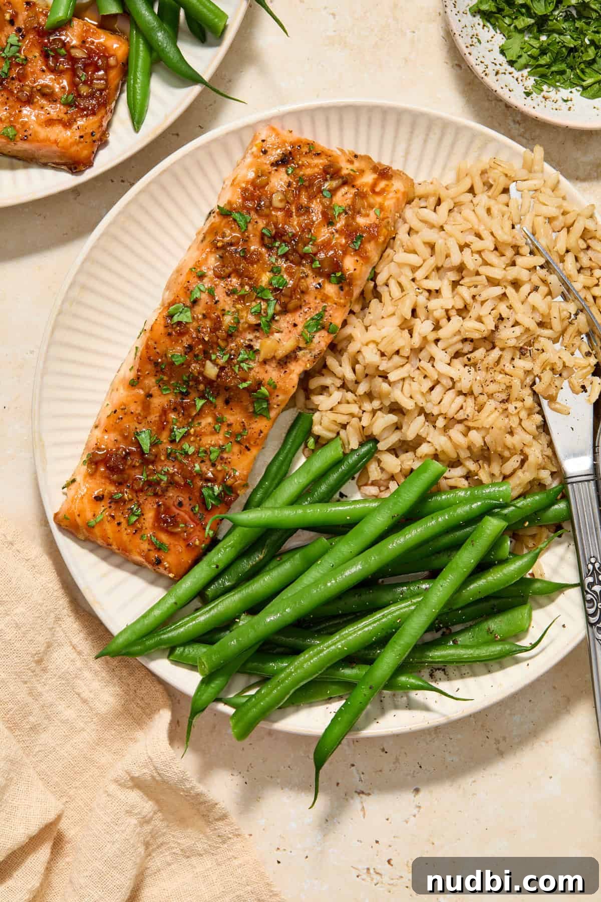 Maple Citrus Glazed Salmon with Tangy Orange Lemon Sauce 2 Citrus glazed salmon filet on plate with green beans and brown rice.