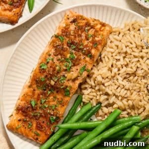 Maple Citrus Glazed Salmon with Tangy Orange Lemon Sauce 9 Maple citrus glazed salmon on plate with rice and vegetables.