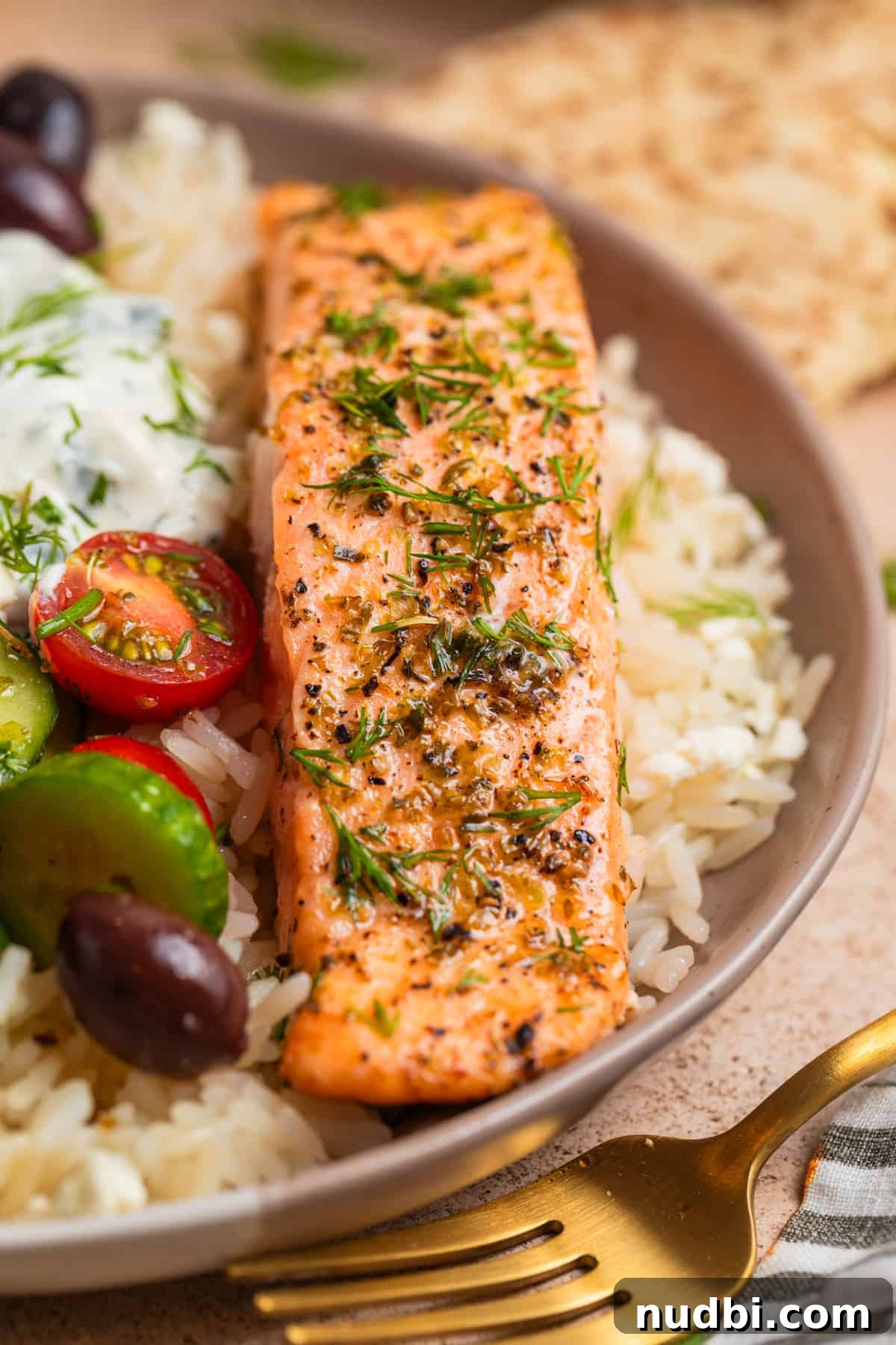 Greek Salmon Rice Bowls with Tzatziki & Lemon Dill Rice 2 Greek salmon over a bed of rice with cucumbers, tomatoes, tzatziki sauce and other toppings.