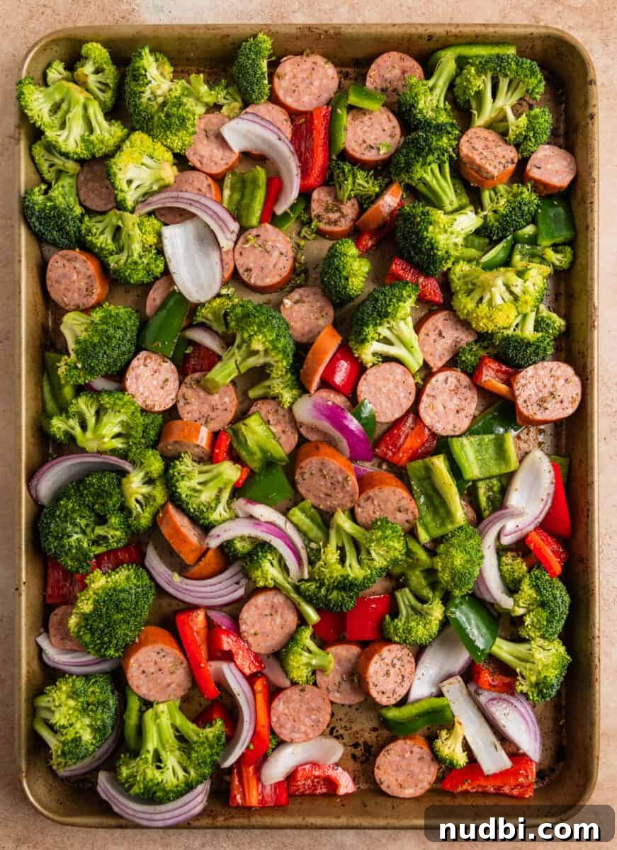 One-Pan Sausage and Veggie Sheet Pan Dinner 5 Sausages and veggies tossed in olive oil and seasoning on baking sheet.