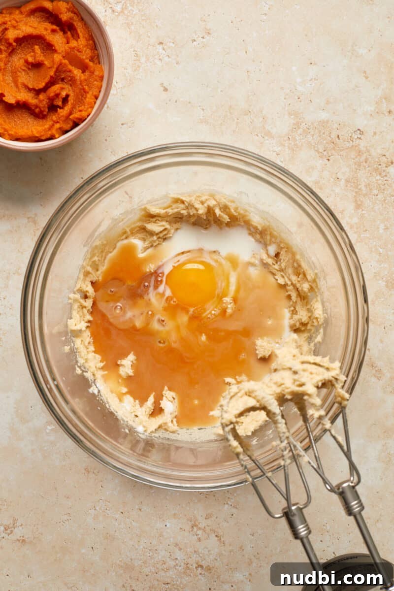Cinnamon Streusel Pumpkin Coffee Cake Recipe for Fall Baking 8 Eggs and milk added to bowl with creamed butter and sugar.