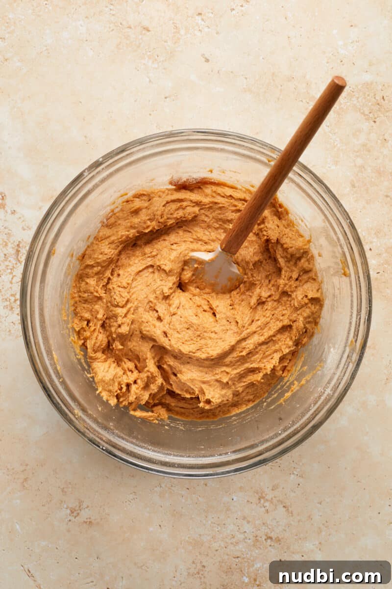 Cinnamon Streusel Pumpkin Coffee Cake Recipe for Fall Baking 10 Prepared pumpkin coffee cake batter mixture with spatula in glass bowl.