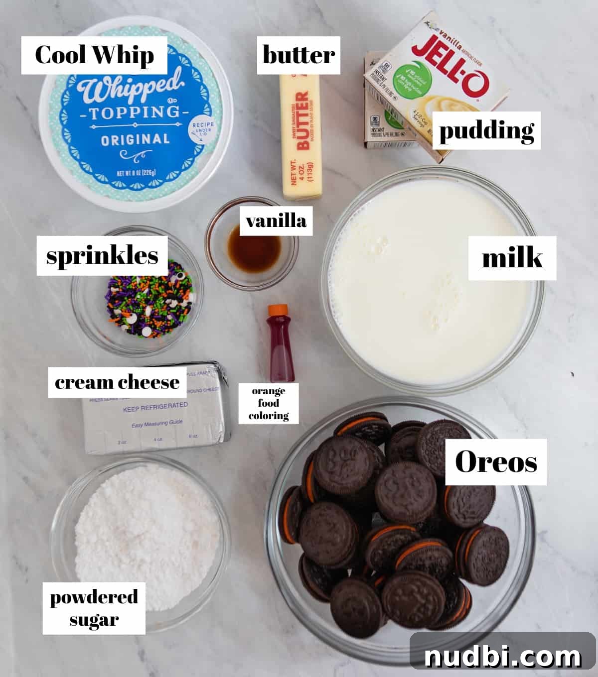 Halloween Oreo Dirt Cake Recipe for Spooky No-Bake Dessert 3 Whipped cream, cream cheese, oreos, pudding and other ingredients labeled on counter.