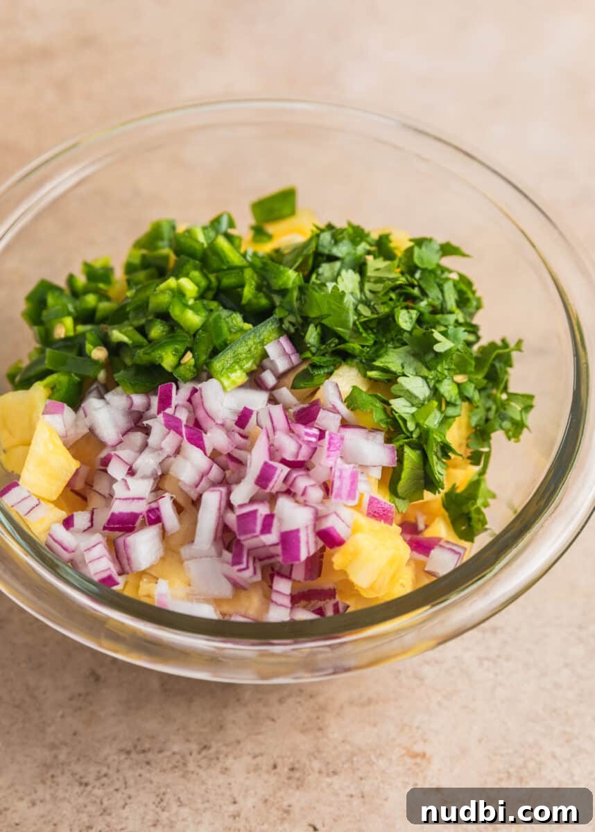 Pineapple Salsa Ground Pork Tacos: Sweet & Spicy Street-Style Recipe 5 Diced pineapple, jalapeños, onion and cilantro in glass bowl.
