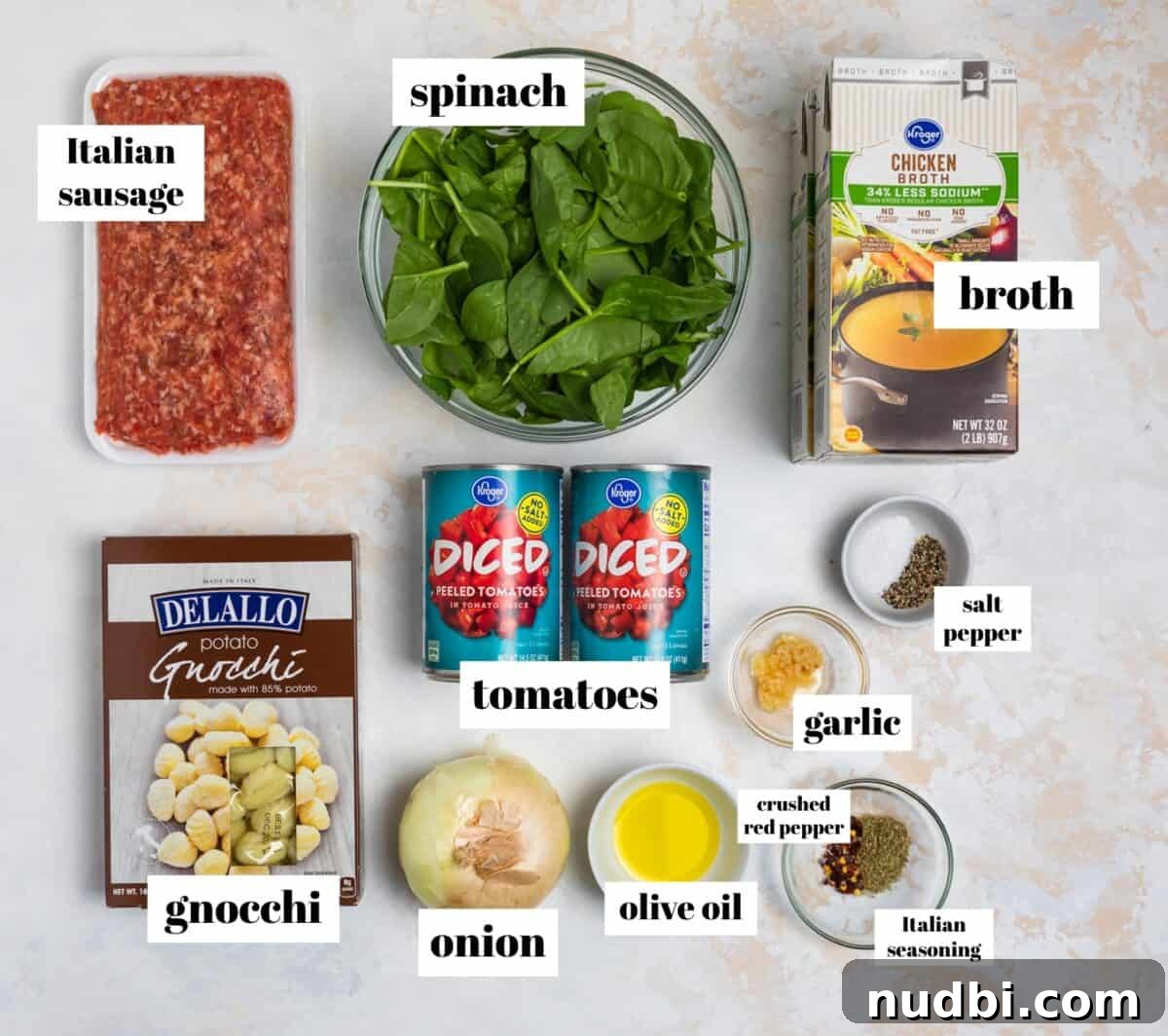 Creamy Italian Sausage Gnocchi Soup Recipe 3 Broth, gnocchi, spinach, sausage and other ingredients labeled on counter.
