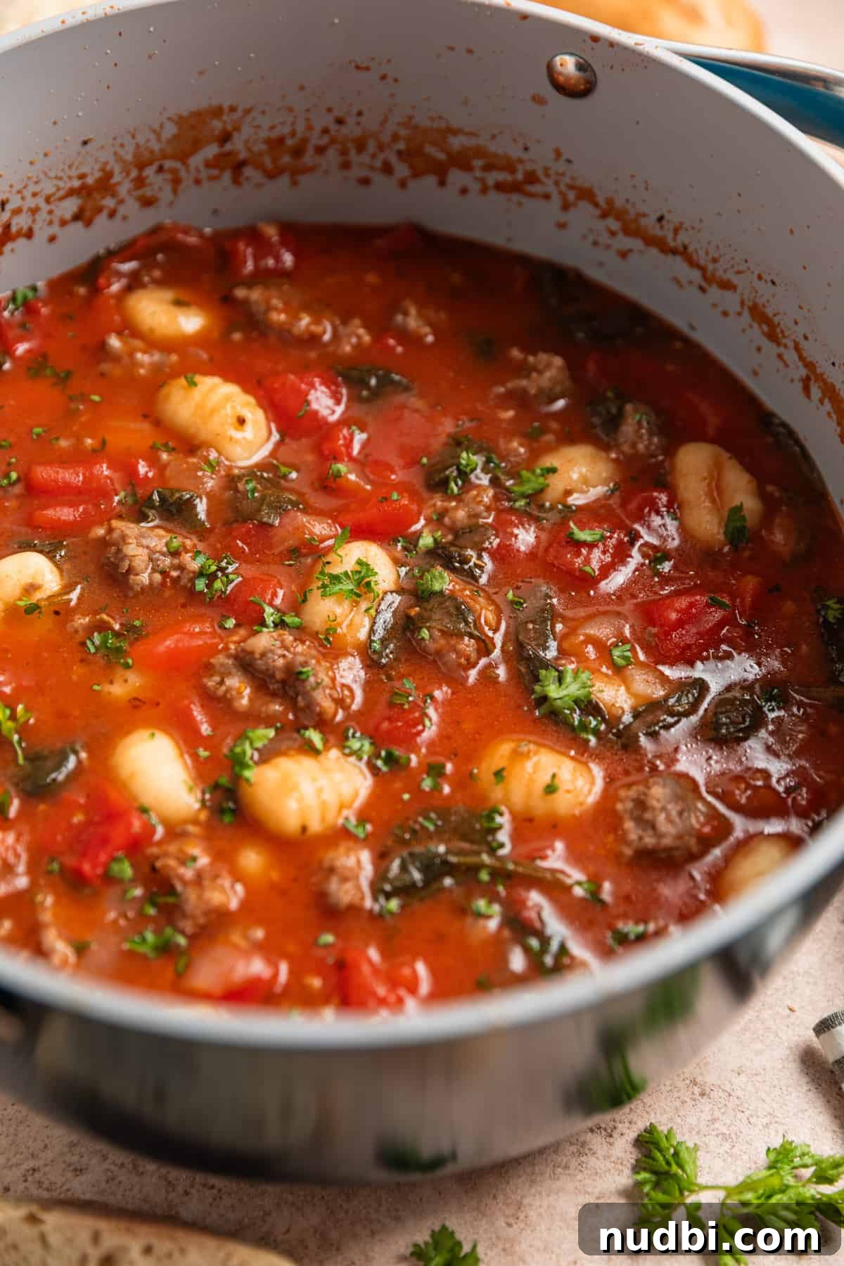 Creamy Italian Sausage Gnocchi Soup Recipe 6 Pot with sausage and gnocchi soup topped with parsley.