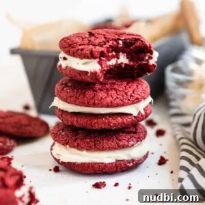 Red Velvet Cake Mix Cookies with Cream Cheese Frosting 13 Stack of red velvet cake mix cookies with bite taken out of top cookie.