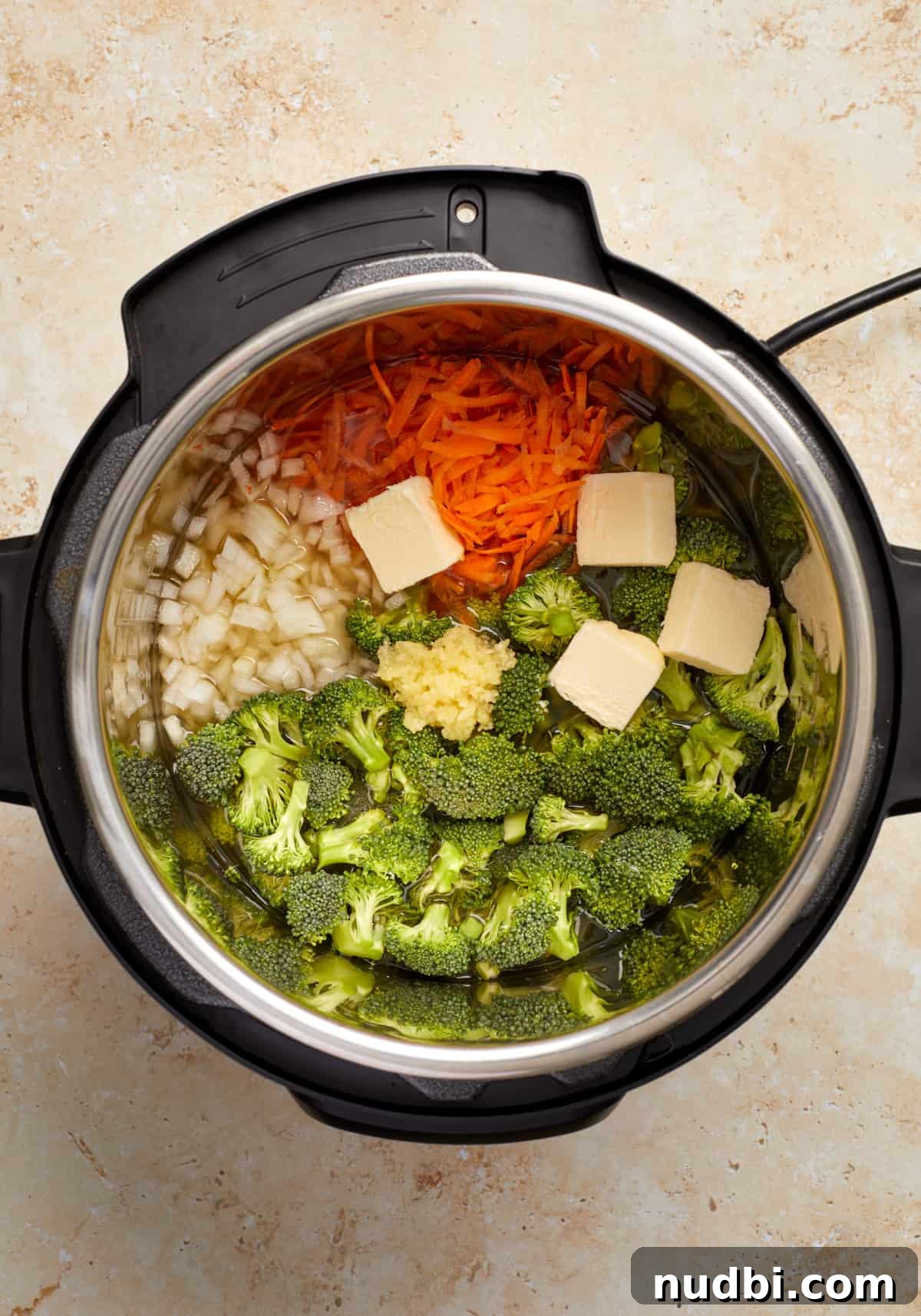 Creamy Broccoli Cheddar Soup Made in the Instant Pot 4 Broccoli, shredded carrots, onion, butter and garlic in Instant Pot.
