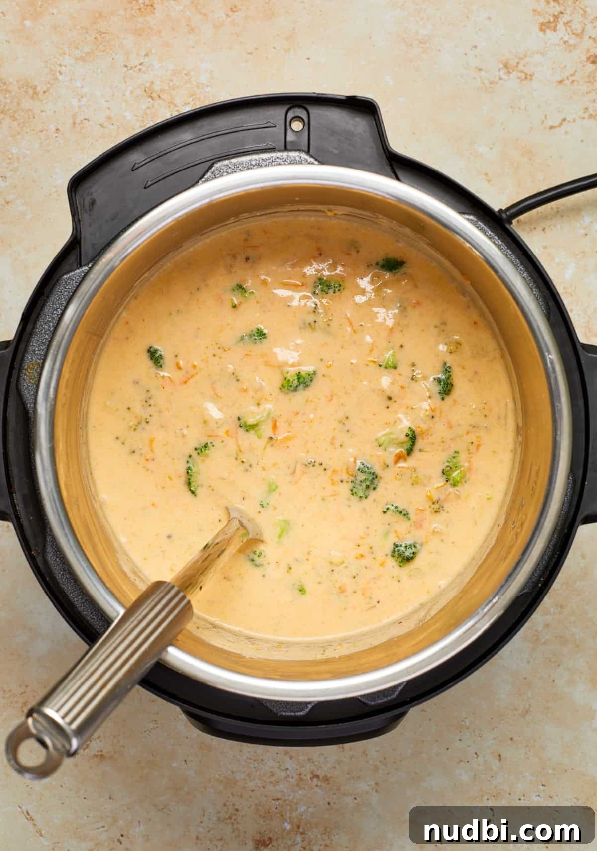 Creamy Broccoli Cheddar Soup Made in the Instant Pot 9 Instant Pot with broccoli cheese soup and ladle placed in.
