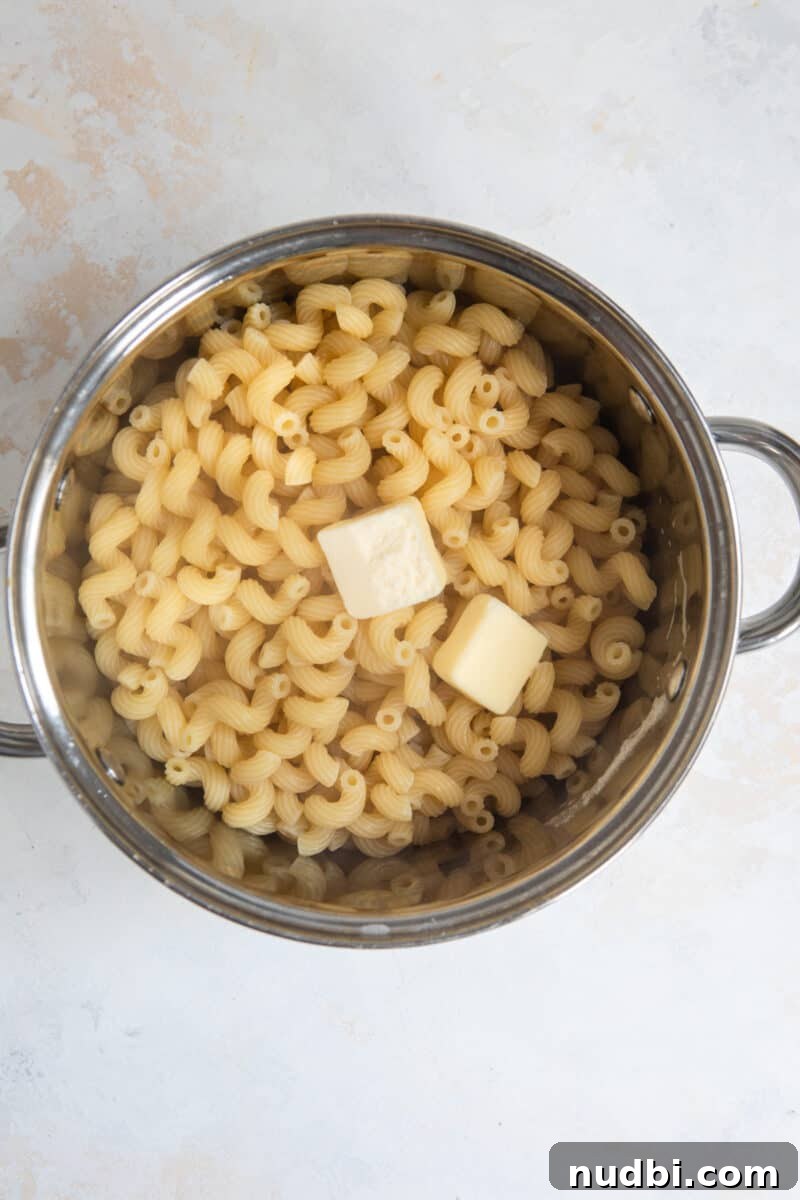 Creamy Cheddar and Gruyère Macaroni Bake 4 Pot with cooked pasta and butter.