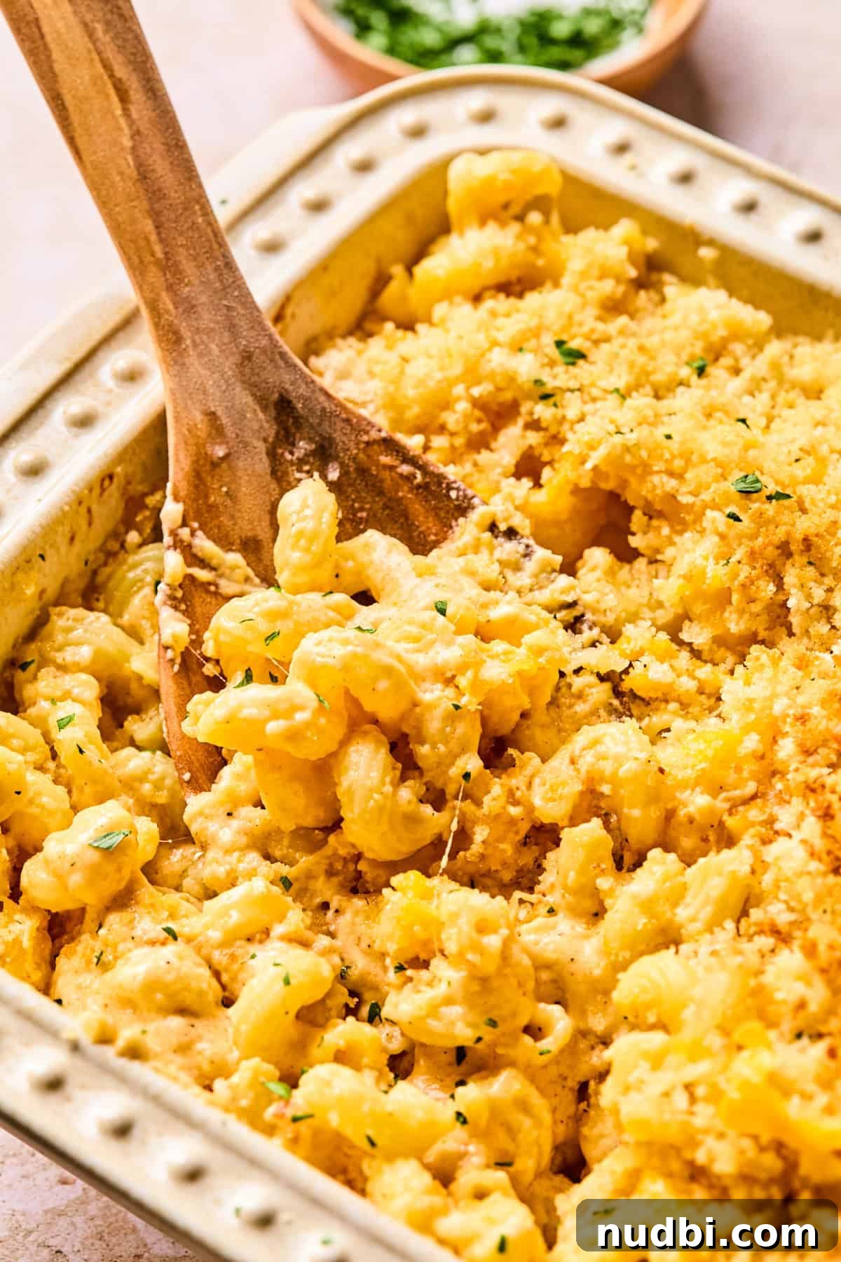 Creamy Cheddar and Gruyère Macaroni Bake 8 Pan of baked mac and cheese with serving spoon.