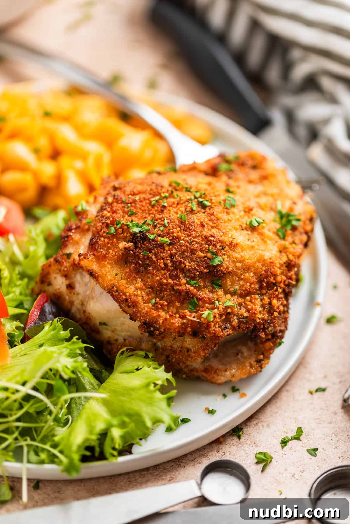 Crispy Parmesan-Crusted Air Fryer Chicken Thighs 9 White plate with breaded chicken thigh, salad and mac and cheese.