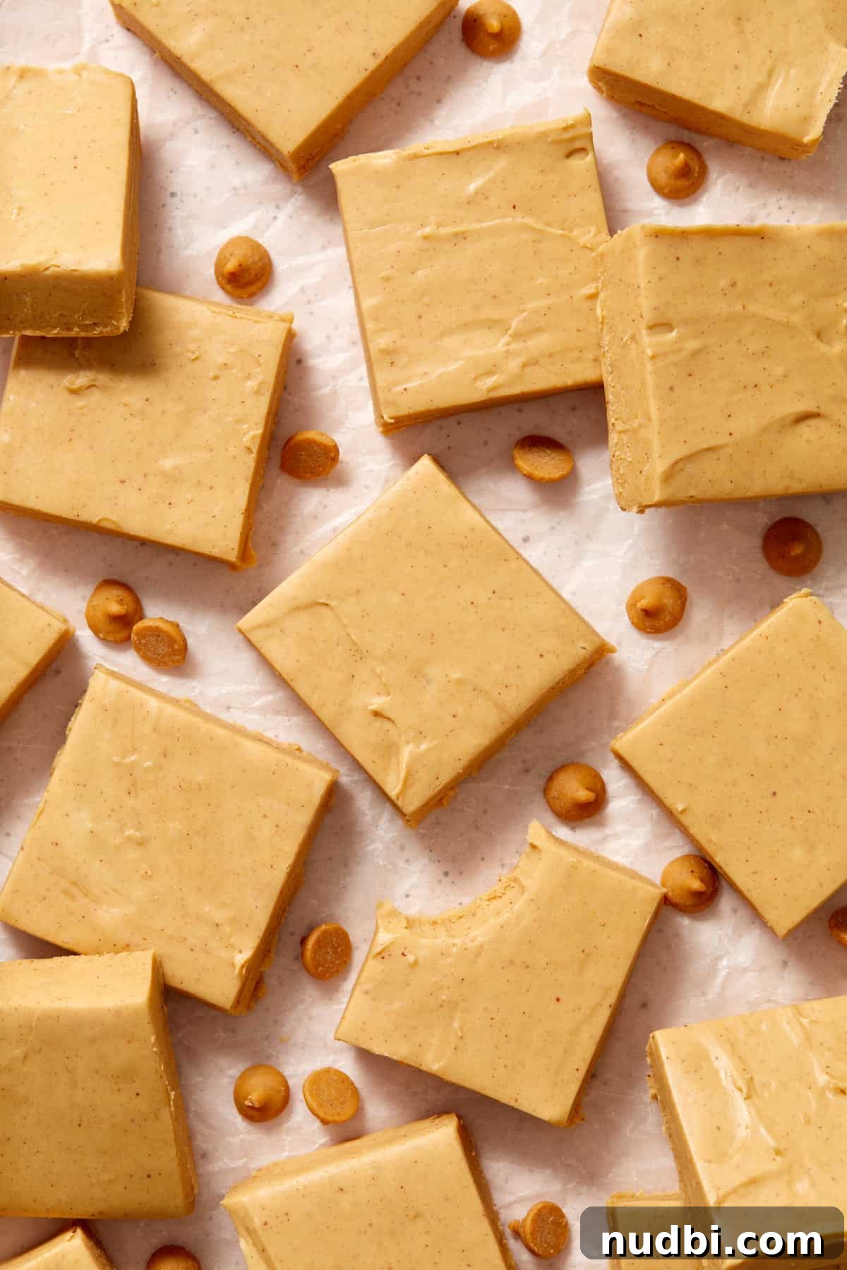 Quick Microwave Peanut Butter Fudge Recipe 2 Peanut butter fudge cut in squares arranged on surface with peanut butter chips.