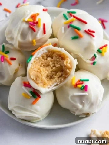 Golden Oreo truffles arranged on white plate with bite taken out of one.